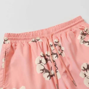 Denim Tears Cotton Flower shorts in pink with floral print, showcasing elastic waistband and drawstring detail, featured on e-commerce page for high-quality replica fashion items.