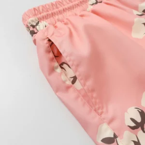 Pink shorts with floral pattern and elastic waistband, featured in Denim Tears Cotton Flower collection.