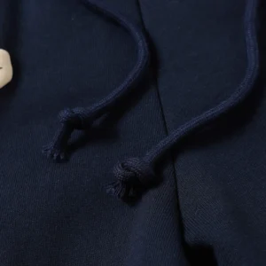 Close-up of dark navy shorts featuring drawstrings and a tag, representing Denim Tears Cotton Flowers collection.