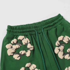 Green shorts featuring cotton flower prints, part of the Denim Tears New Cotton Flowers collection, highlighting trendy streetwear design.