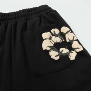 Repsgoat black cotton sweatpants with elastic waistband and beige floral graphic on back pocket