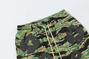 DENIM TEARS Cotton Flower shorts in camouflage print featuring floral foam flocking details, showcasing elastic waistband and drawstring.