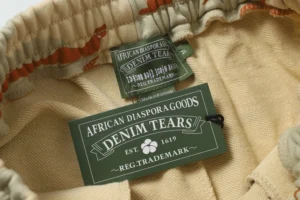 African Diaspora Goods Denim Tears beige cotton fabric label and trademark tag inside garment