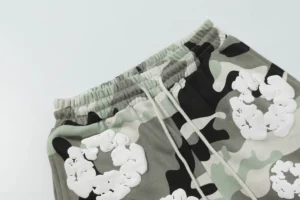 Denim Tears Cotton Flower camo shorts featuring foam flocking print, showcasing a blend of grey and black camouflage patterns with white floral designs.