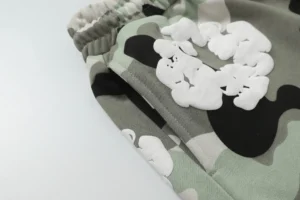 Denim Tears Cotton Flower shorts featuring foam flocking camo print in shades of green, black, and white, highlighting the unique design and texture.