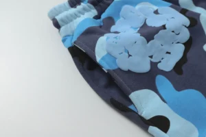 Denim Tears Cotton Flower shorts featuring a blue camouflage pattern, showcasing high-quality fabric and elastic waistband, ideal for luxury replica clothing enthusiasts.