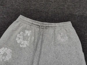 No brand or model information visible on gray sweatpants with white floral patterns and drawstring waistband