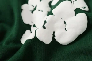 DENIM TEARS Cotton Flower design on green fabric, showcasing high-quality foam print details for a trendy hooded sweatshirt.