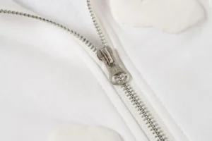 YKK zipper in silver metal on white cotton fabric accessory with smooth stitching detail