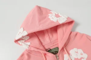 Pink hooded sweatshirt featuring floral foam print design, part of the DENIM TEARS Cotton Flower collection, emphasizing stylish and eco-friendly apparel.