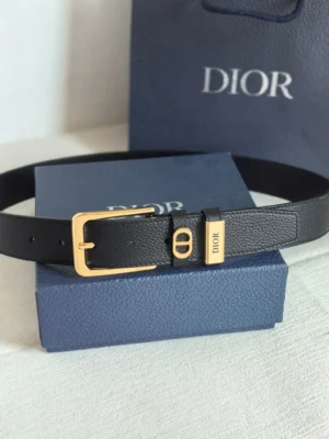 Dior Unisex CD Logo Leather Belt in black with gold buckle, placed on a blue Dior box, showcasing luxury fashion accessory details.