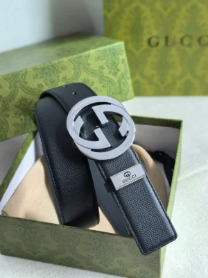 Gucci men's leather belt featuring a double G logo buckle and a metal tag with "GUCCI" in a decorative box, highlighting luxury craftsmanship and brand recognition.