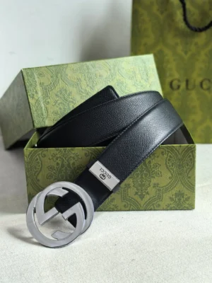Gucci men's leather belt with double G logo buckle, presented in a green ornate box, showcasing luxury craftsmanship and brand recognition.