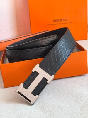 Hermes men's double-sided leather belt in black with iconic "H" buckle, displayed in an orange Hermes box, showcasing luxury craftsmanship and exquisite texture.