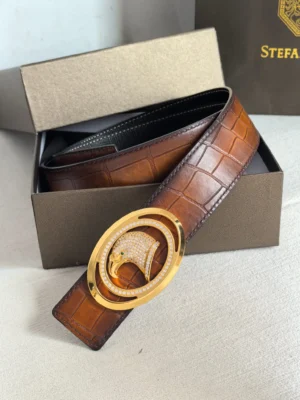 Luxury Stefano Ricci men's leather belt featuring a gold oval buckle with embellishments, displayed in an elegant box.