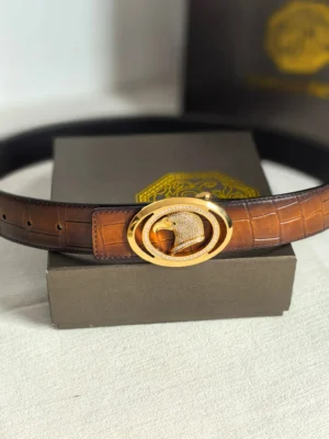 Luxury leather belt by Stefano Ricci featuring a distinctive gold buckle, displayed on a neutral background with a branded box.