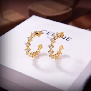 Celine's new star earrings featuring a gold design with sparkling stones, displayed on a branded Celine box, emphasizing their stylish and charming appeal.