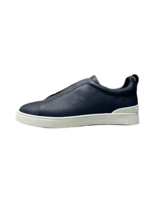 Minimalist navy leather slip-on shoes for men with a clean silhouette, elastic hidden panel, and lightweight rubber sole, showcasing luxury craftsmanship.