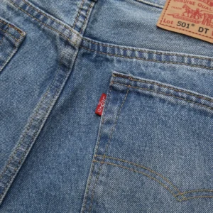 DENIM TEARS Water Washed Embroidery Vintage jeans featuring light blue denim fabric, red tab detail, and classic five-pocket design.