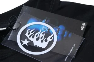 Hellstar brand tag featuring graphic logo and blue background, attached to black long sleeve shirt.