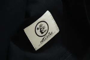 Hellstar clothing label featuring logo and brand name on black fabric, highlighting quality and design of the Hellstar White Long Sleeves shirt.