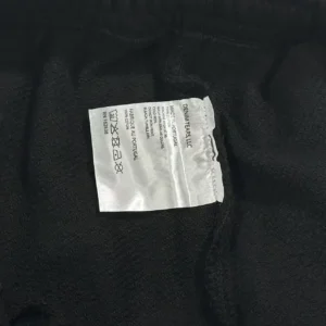 Denim Tears LLC clothing label made in Portugal 100% cotton with washing instructions on black fabric