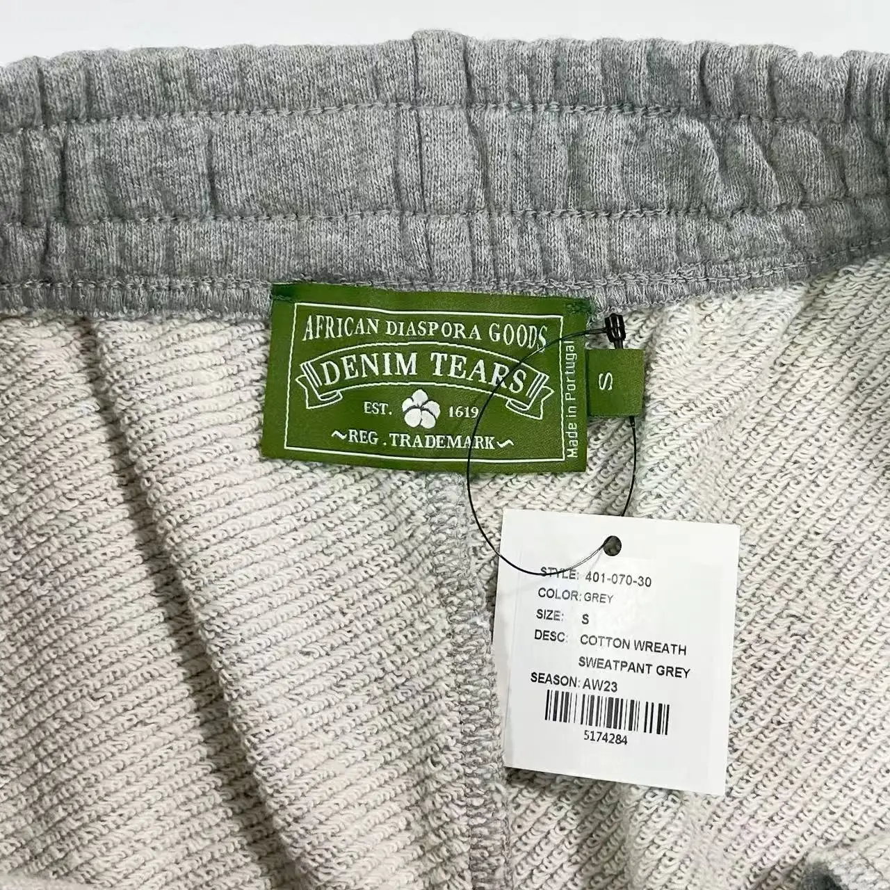 Denim Tears Main Line Hemp Grey Cotton pants tag showing brand name, size S, and fabric details.