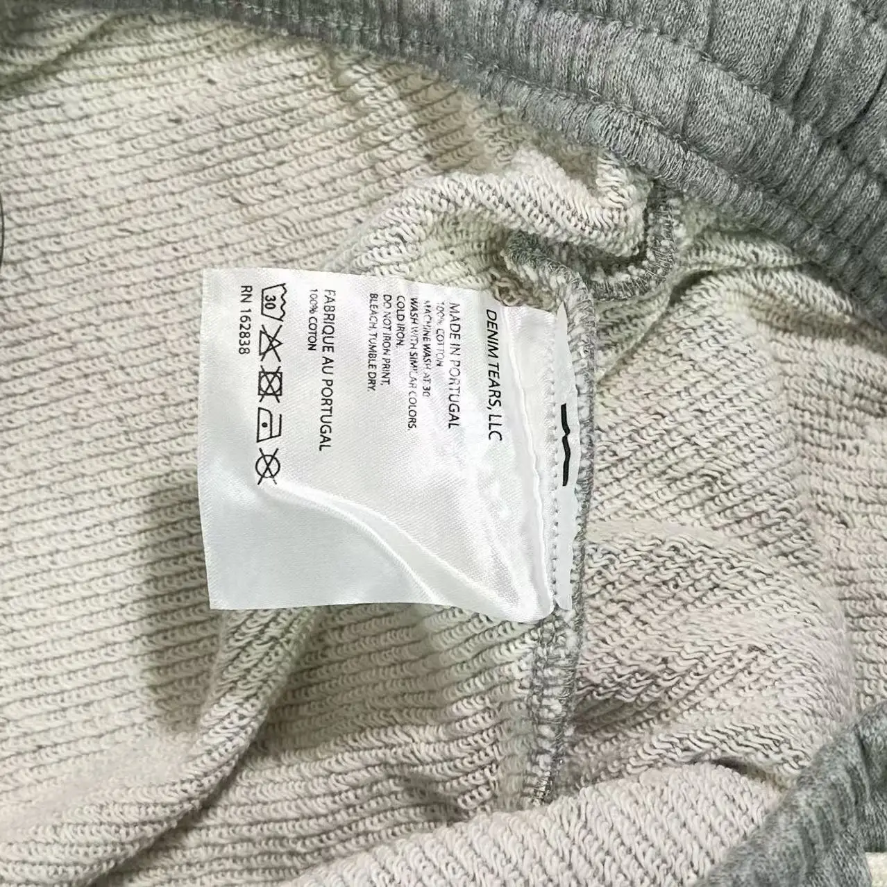 Label of Denim Tears Main Line Hemp Grey Cotton pants, showing care instructions and brand details.