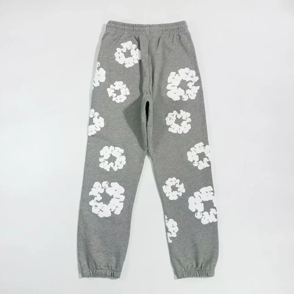 No brand or model visible; gray sweatpants with white floral circular patterns, cotton fabric