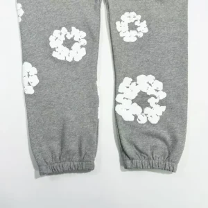 Grey cotton pants featuring white floral prints, part of the Denim Tears Main Line Hemp collection, designed for casual wear.