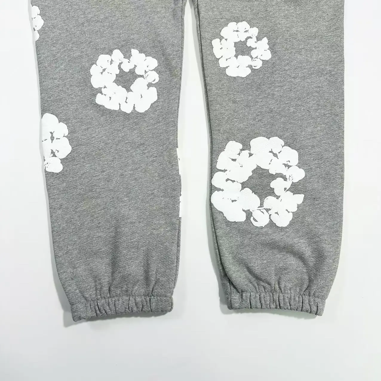 Grey cotton pants featuring white floral prints, part of the Denim Tears Main Line Hemp collection, designed for casual wear.