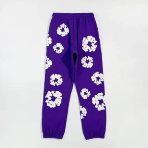 Purple sweatpants featuring white kapok flower patterns, part of the Denim Tears mainline collection, showcasing unique fabric texture and design.