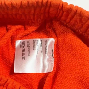 Denim Tears fleece sweatpants orange cotton fabric made in Portugal with care instructions label