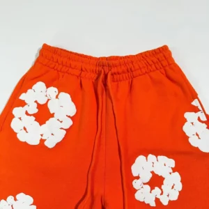 Fear of God Essentials sweatpants orange cotton blend pants with white floral patterns and elastic waistband