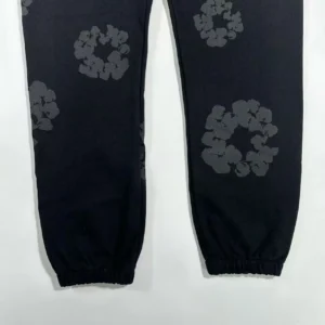 No brand or model visible on black sweatpants with elastic cuffs and grey floral pattern cotton fabric