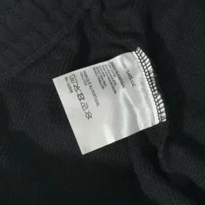 Denim Tears black cotton fabric garment with care label made in Portugal