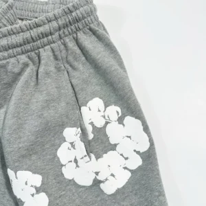 Grey cotton shorts featuring a floral design, part of the Denim Tears Main Line collection, showcasing soft fabric texture and elastic waistband.