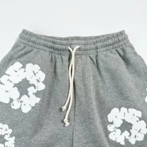 Grey cotton shorts featuring white floral designs and drawstring waistband, part of Denim Tears Main Line Hemp collection.