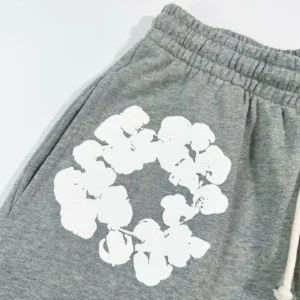 Grey cotton shorts featuring a white floral print design, part of the Denim Tears Main Line collection.