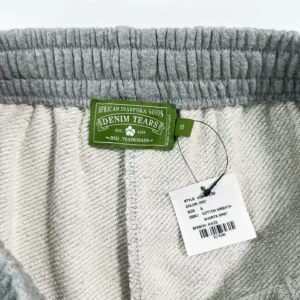Denim Tears Main Line Hemp Grey Cotton shorts tag and care label, featuring brand logo and product information.