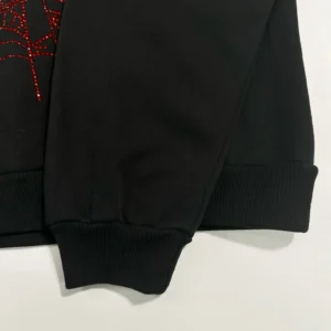 Black hoodie sleeve featuring red diamond bead design and ribbed cuff, part of the Sder Black and Red OG Hot Diamond Bead Mesh Hoodie by SP5DER.
