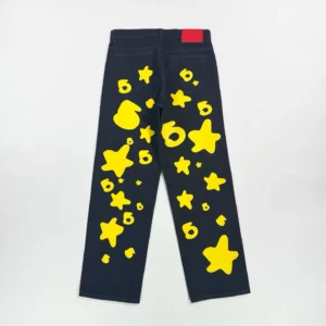 Sp5der Beluga Star Original Color Jeans featuring a dark fabric with vibrant yellow star and shape patterns on the legs.