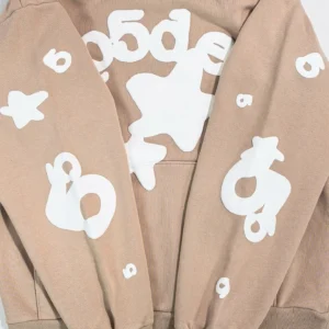 Sder Camel Beluga Hoodie 05 featuring a beige fabric with white graphic designs, including numbers and shapes, highlighting its trendy streetwear style.