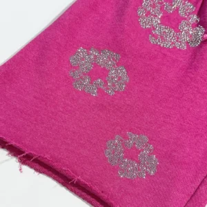 No brand name or product details visible to generate SEO-optimized alt text for this pink fabric with silver rhinestone floral patterns.