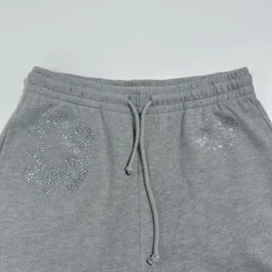 Grey sweatpants featuring diamond flower design on the front, part of Denim Tears collection.