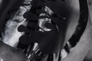 Abstract design featuring dark, layered shapes on a textured background, representing the Hellstar Studios G hoodie in a stylish and artistic manner.