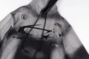 Hellstar Studios G hoodie featuring a black and gray design, prominent logo, and drawstring hood, showcasing premium craftsmanship for sale at .00.