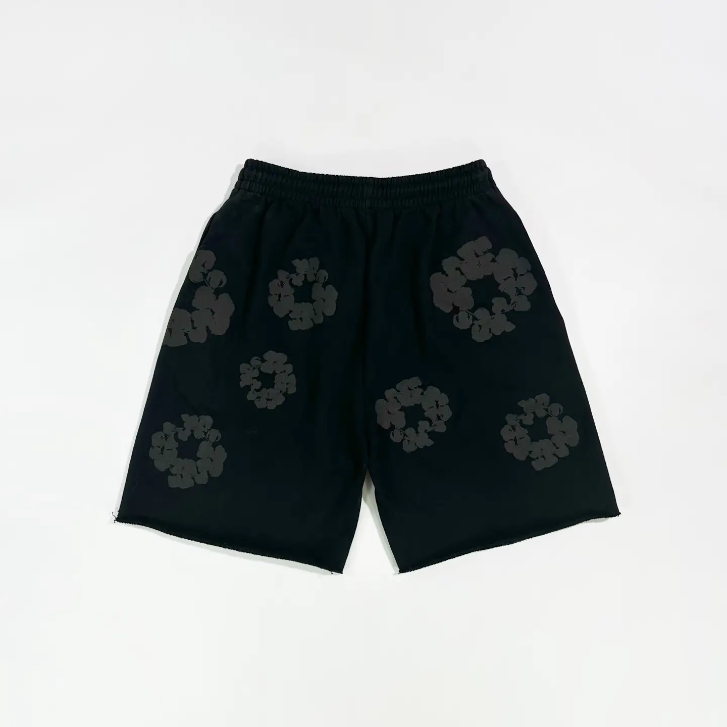 No brand visible black shorts with dark floral print and elastic waistband, cotton material