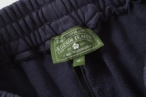 Denim Tears hoodie navy blue cotton fabric with green brand logo label and elastic waistband detail