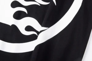 NS logo printed on black and white cotton T-shirt from Hellstar Studios, showcasing design detail.